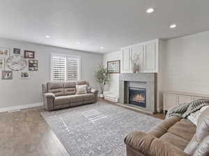 Open living space featuring wood-finish flooring, recessed lighting, and a window with plantation shutters
