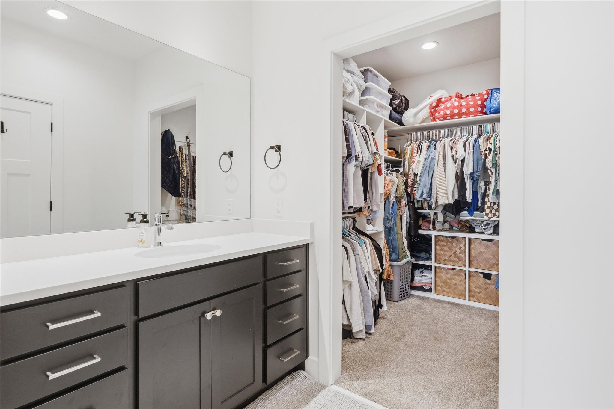 Spacious walk-in closet featuring built-in shelving, hanging rods, and recessed lighting