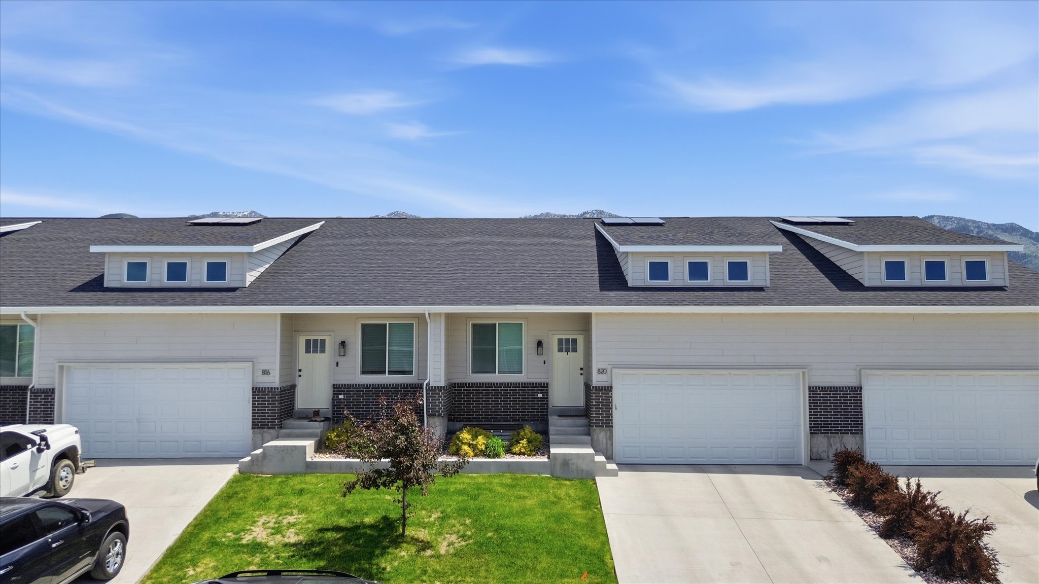 Contemporary multi-unit residence with light-toned siding and dark shingle roofing