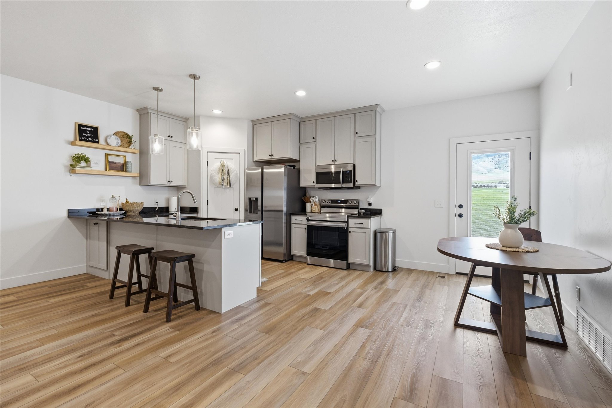Kitchen featuring light gray cabinetry, stainless steel appliances, and dark countertops