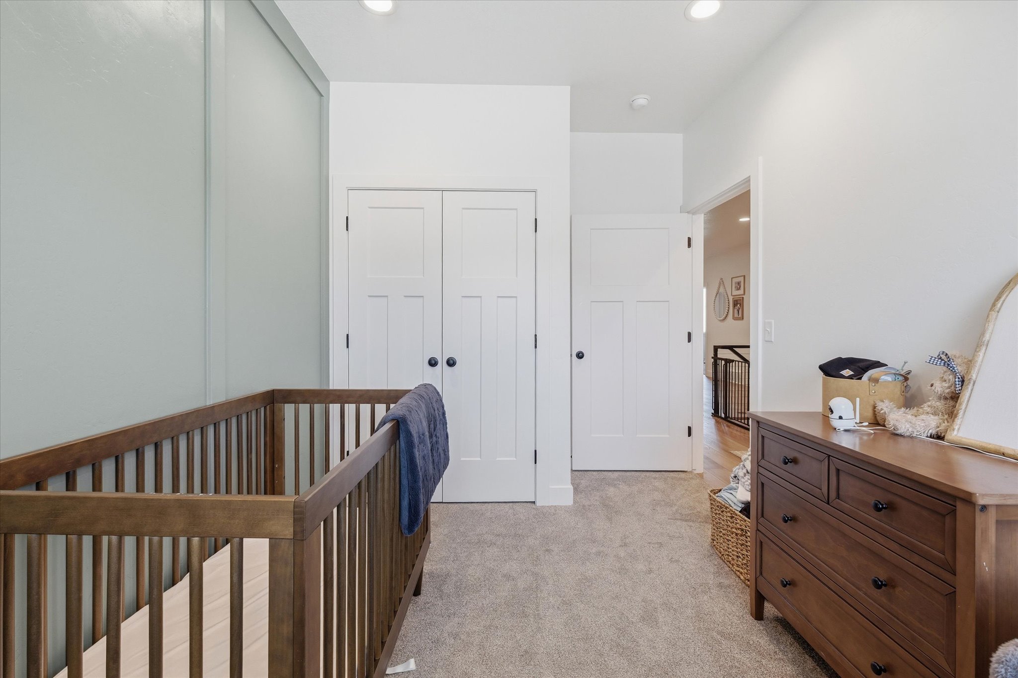 Carpeted room featuring a light-toned accent wall, modern paneled doors, and recessed lighting