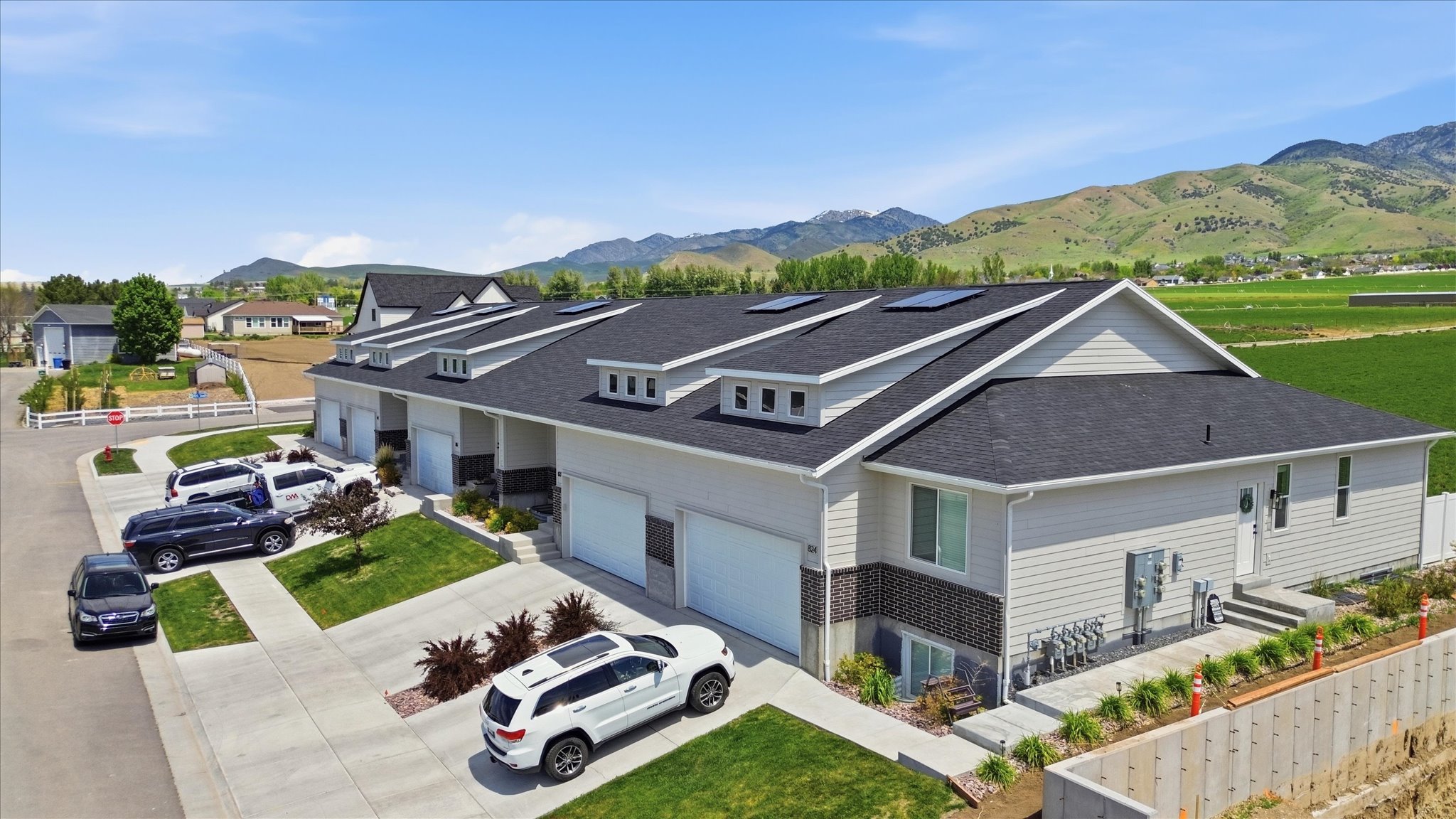 Contemporary multi-unit residence with light-colored siding and dark shingle roofing