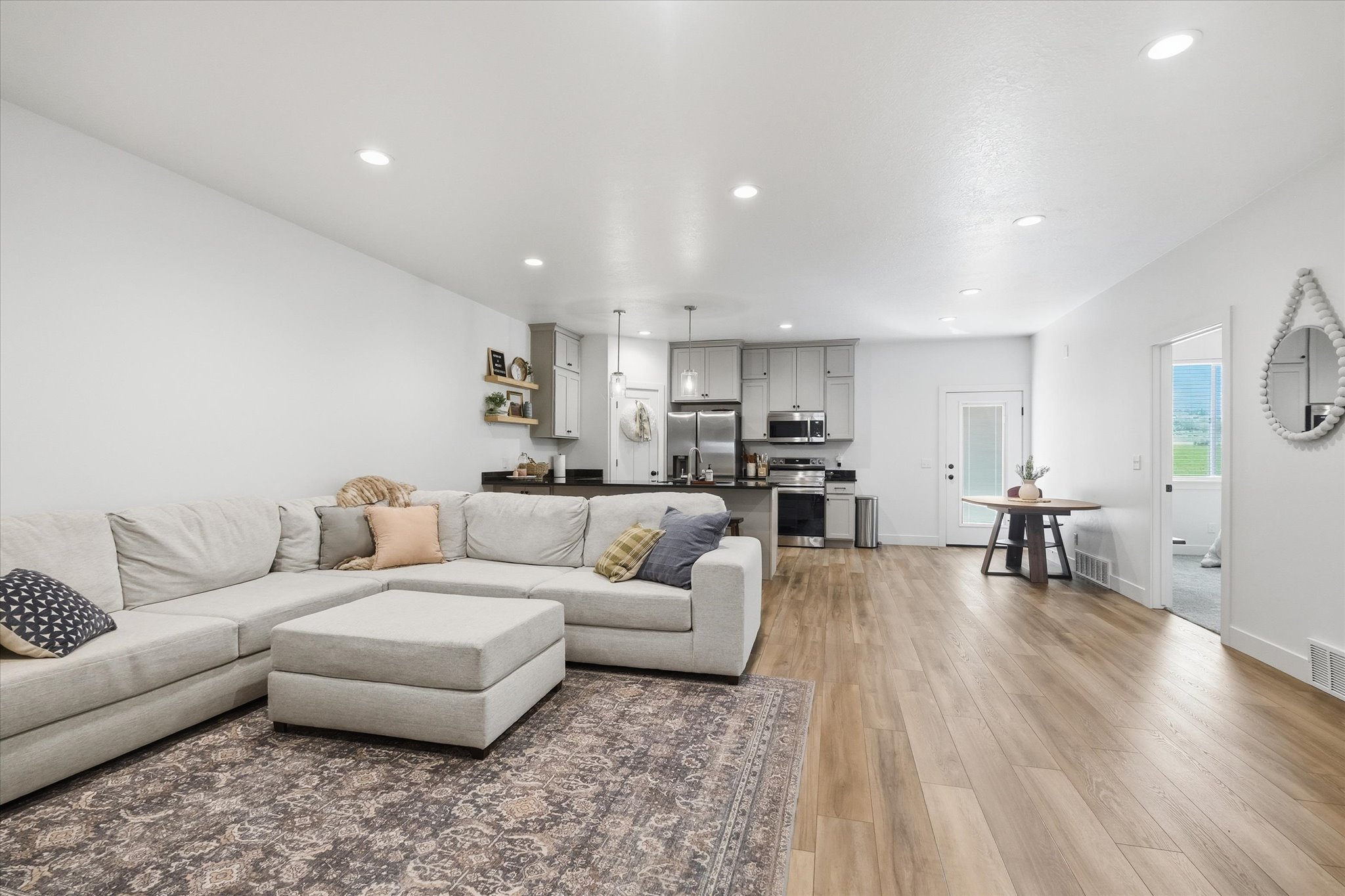Spacious open-concept living area featuring wood-finish flooring and recessed lighting