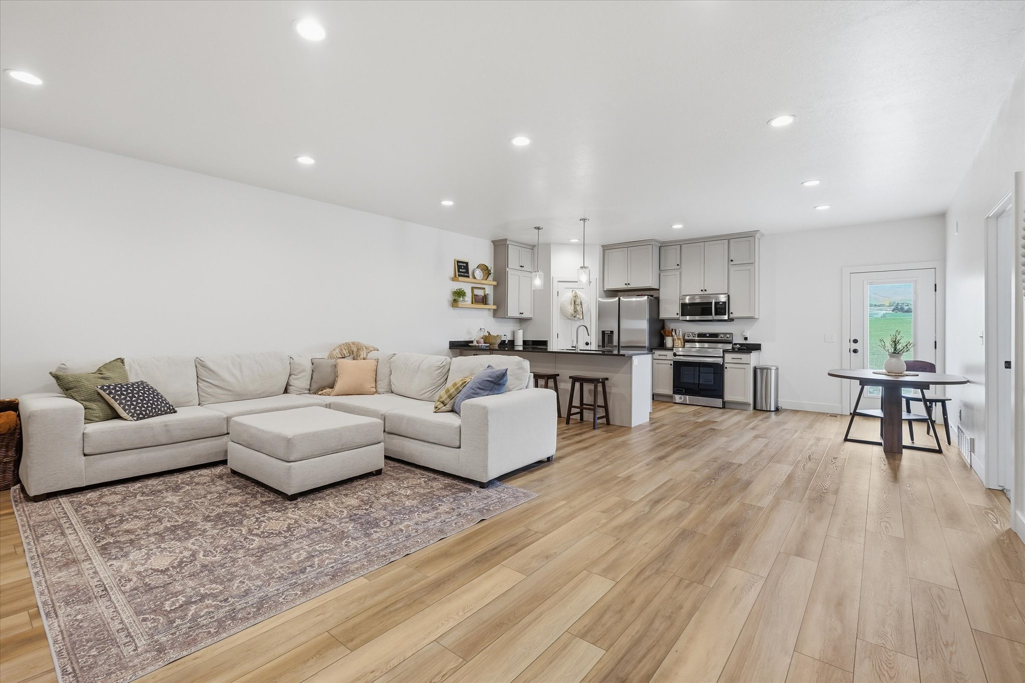 Open-concept living space featuring wood-finish flooring, recessed lighting, and a modern kitchen