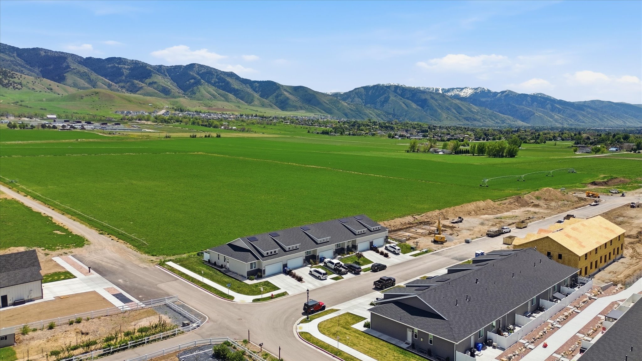 Expansive green fields and distant mountains form a scenic backdrop to this developing community