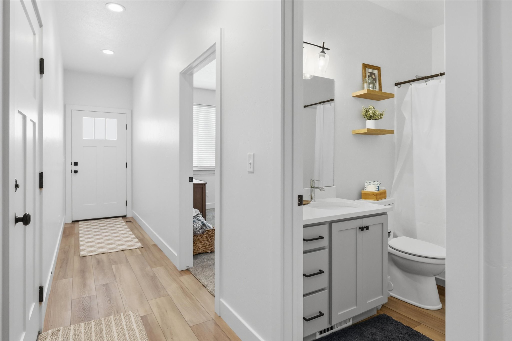 Light wood-finish flooring extending from the entryway into other areas