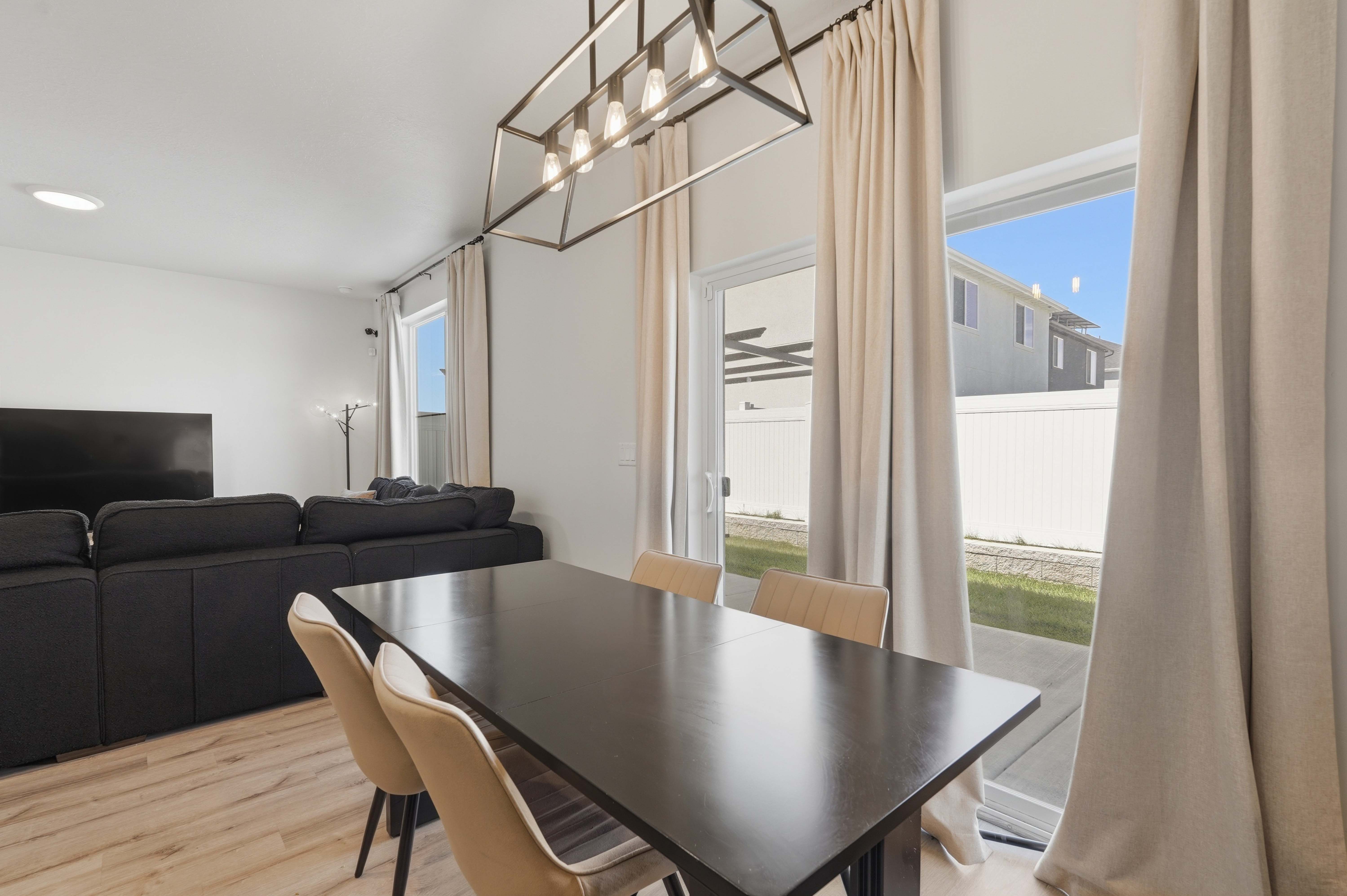 Dining area featuring a contemporary linear chandelier and light wood-finish flooring