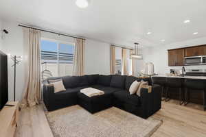 Open-concept common area featuring wood-finish flooring, recessed lighting, and a window with horizontal blinds