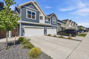 Contemporary townhouse exterior featuring blue vertical and horizontal siding, white trim, and a prominent gable roofline