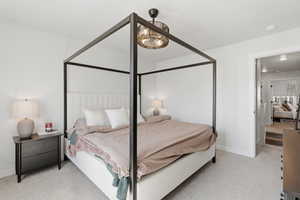 Carpeted bedroom featuring neutral wall paint, a built-in light fixture, and an open doorway