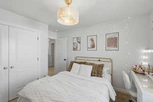 Bedroom featuring a drum pendant light fixture, white walls, and carpet flooring