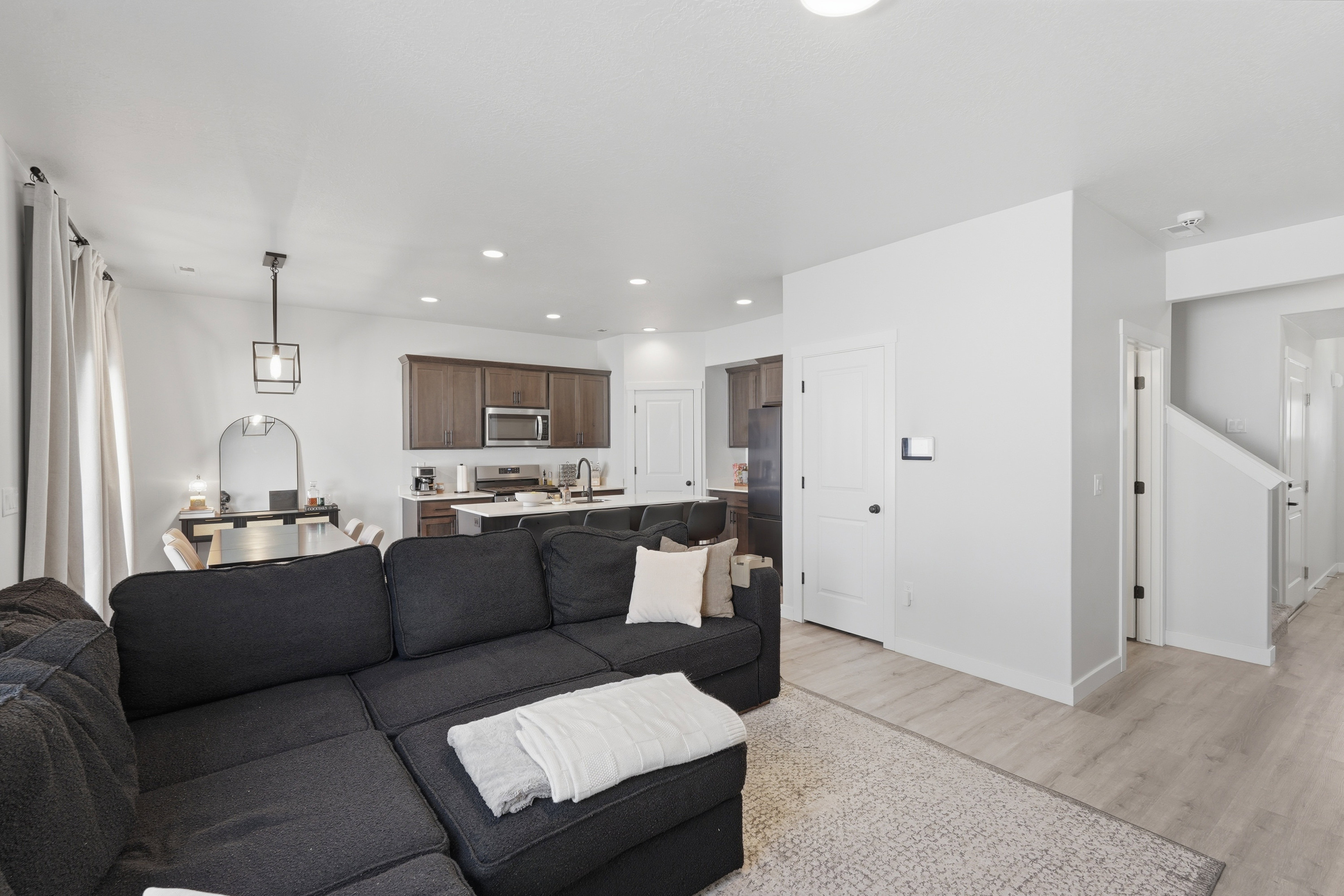 Open-concept living area featuring light wood-finish flooring and recessed lighting