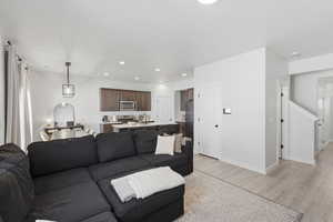 Open-concept living area featuring light wood-finish flooring and recessed lighting