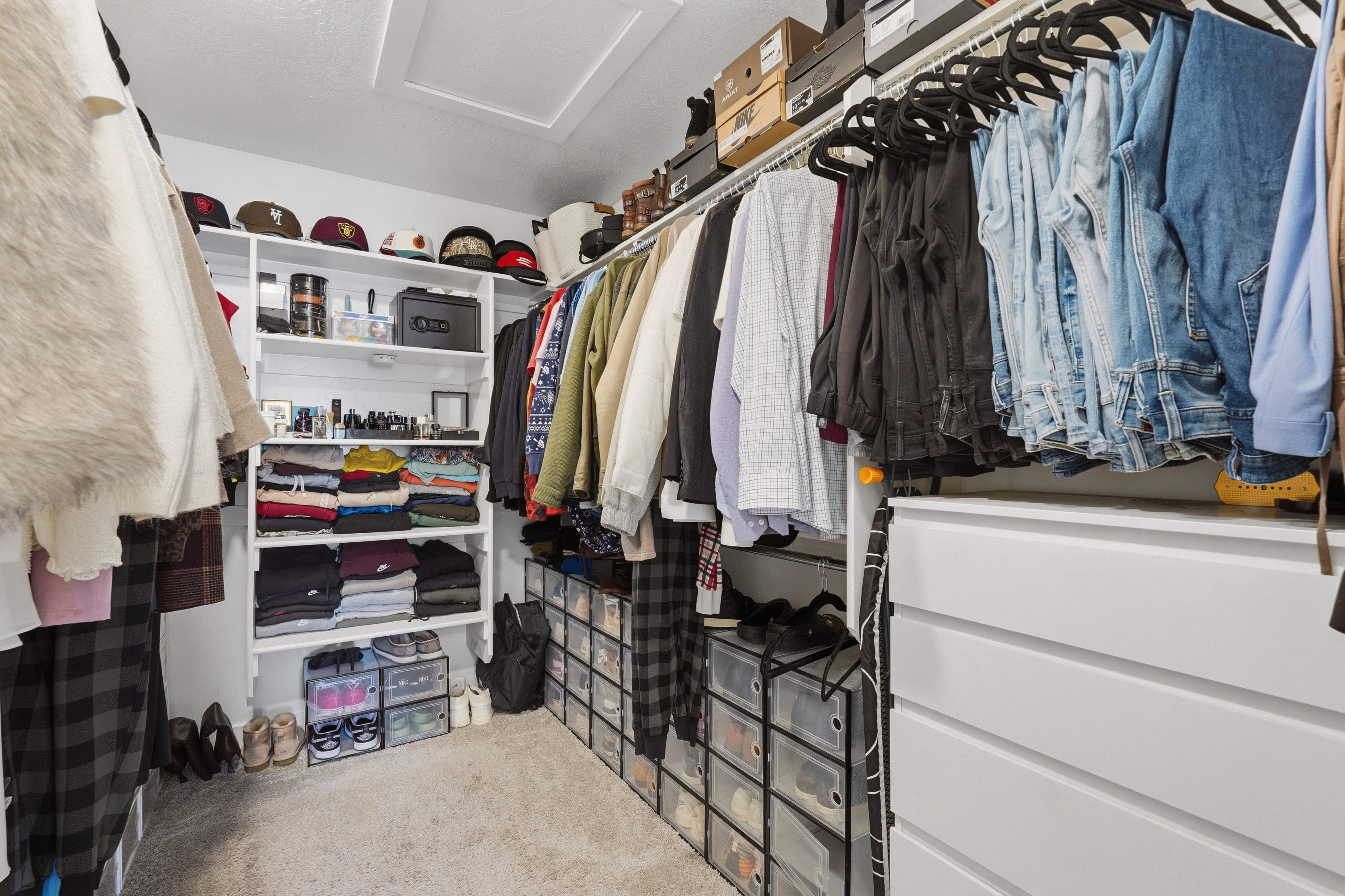 Walk-in closet featuring built-in shelving, hanging rods, an integrated chest of drawers, and carpeted flooring