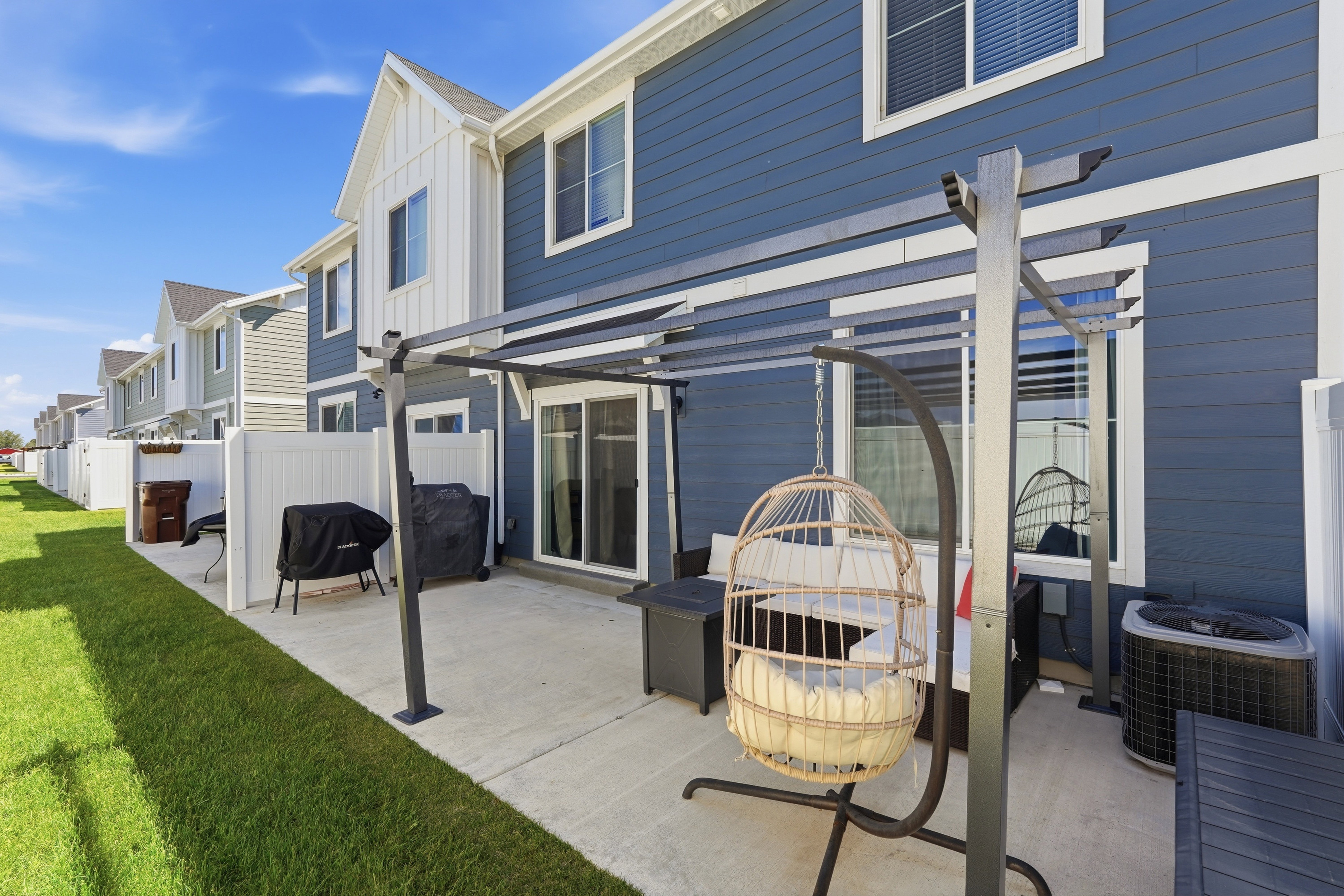 Rear patio featuring a pergola structure, concrete paving, and a sliding glass door entry