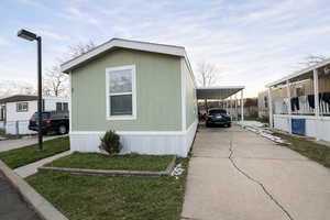 Single-story residence featuring light green vertical siding and white trim