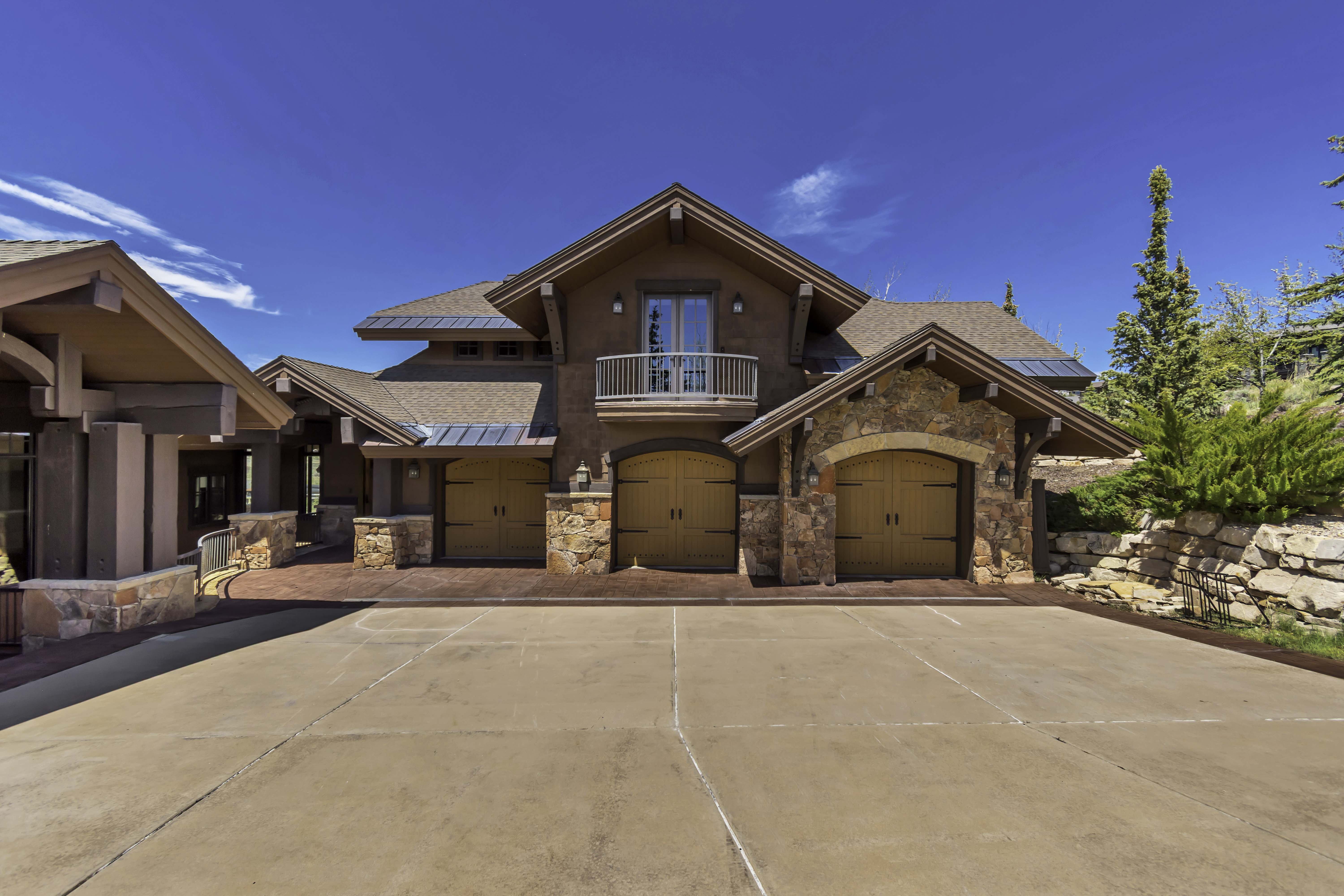 Craftsman-style facade with stone accents, a multi-gabled roof, and a three-car garage