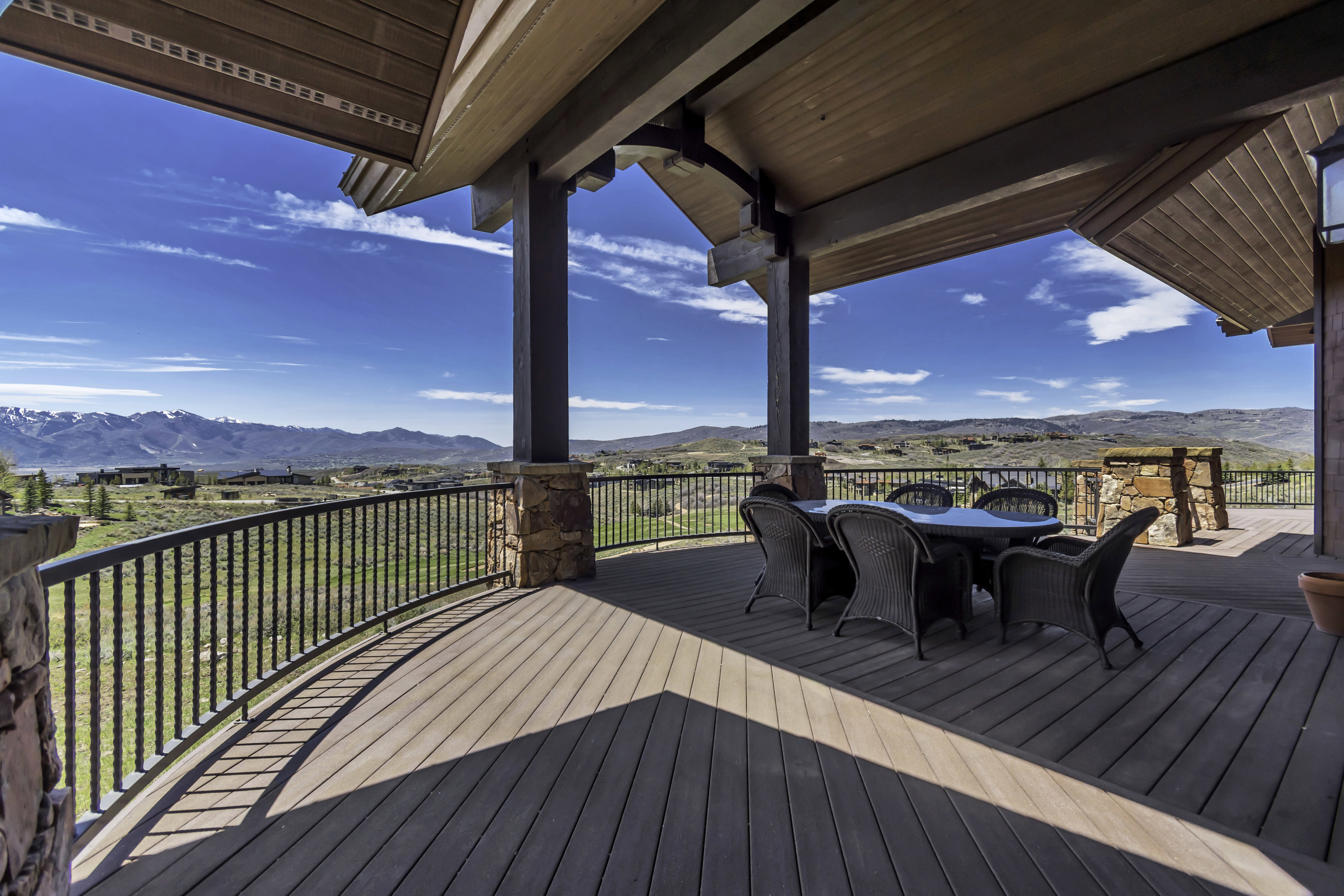 Expansive outdoor deck featuring wood-finish flooring and a decorative metal railing