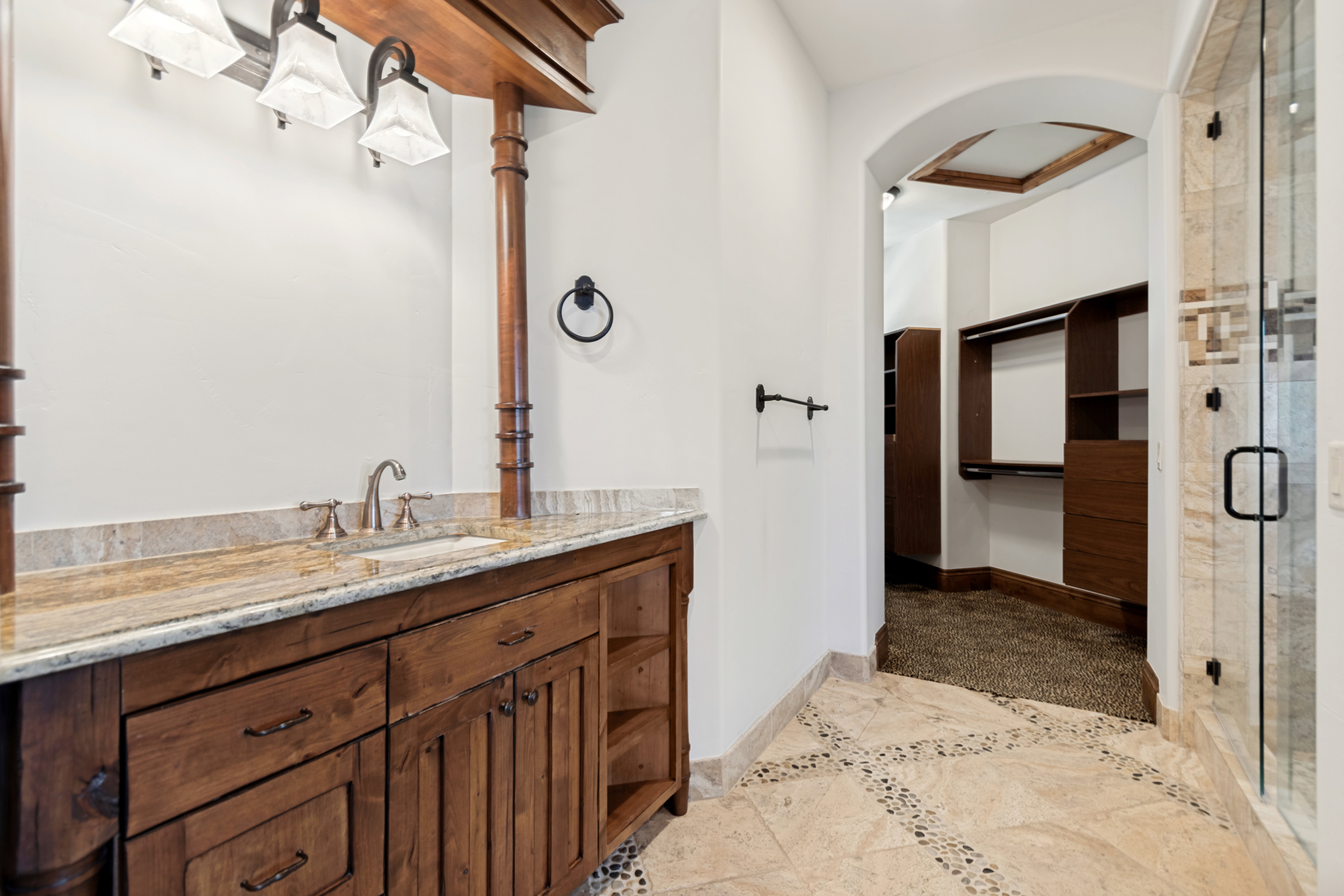 Warm wood-finish vanity featuring dual sinks with a light-toned countertop
