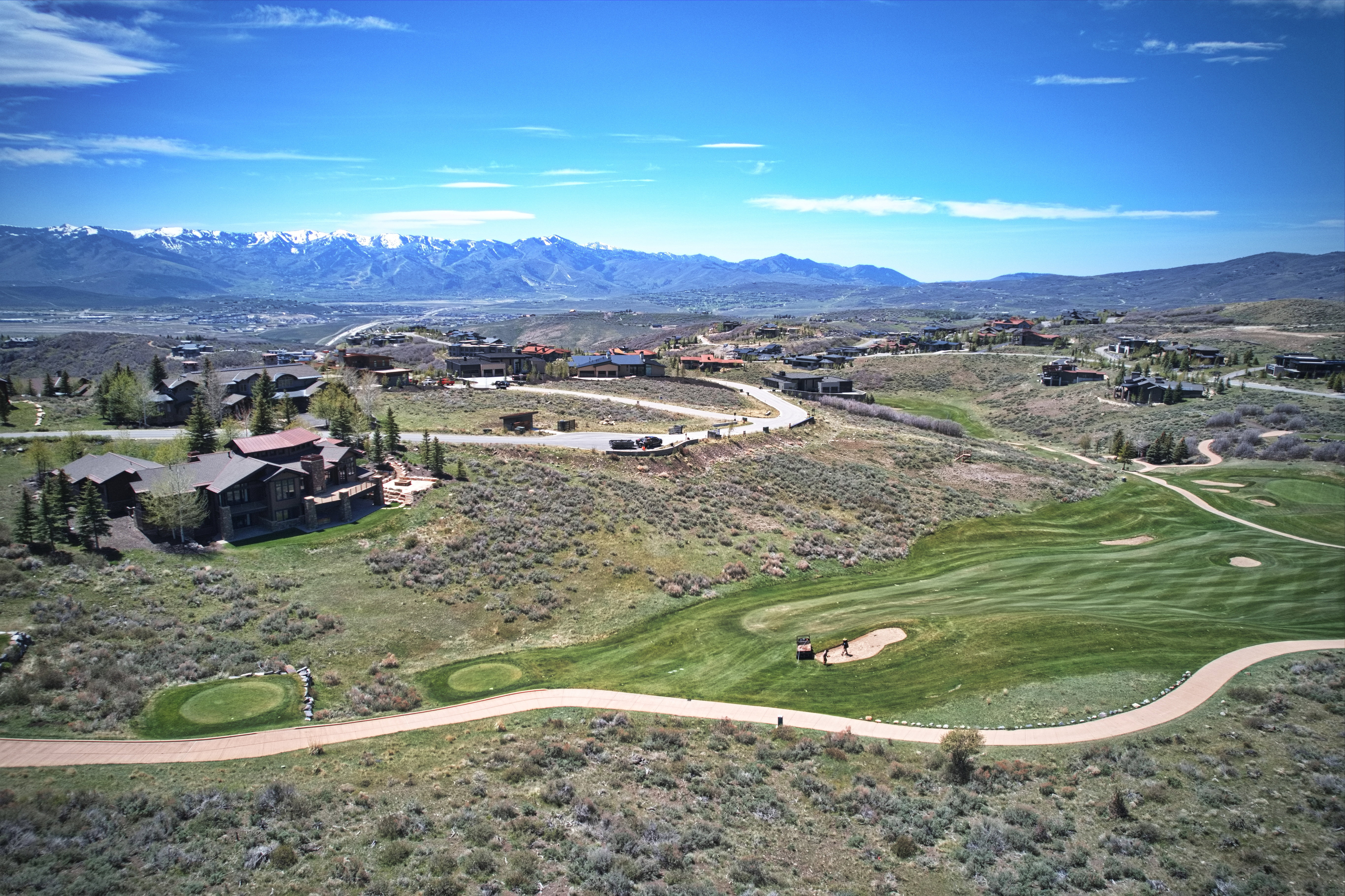 Expansive golf course setting featuring manicured greens and fairways, surrounded by custom residences and winding golf cart paths