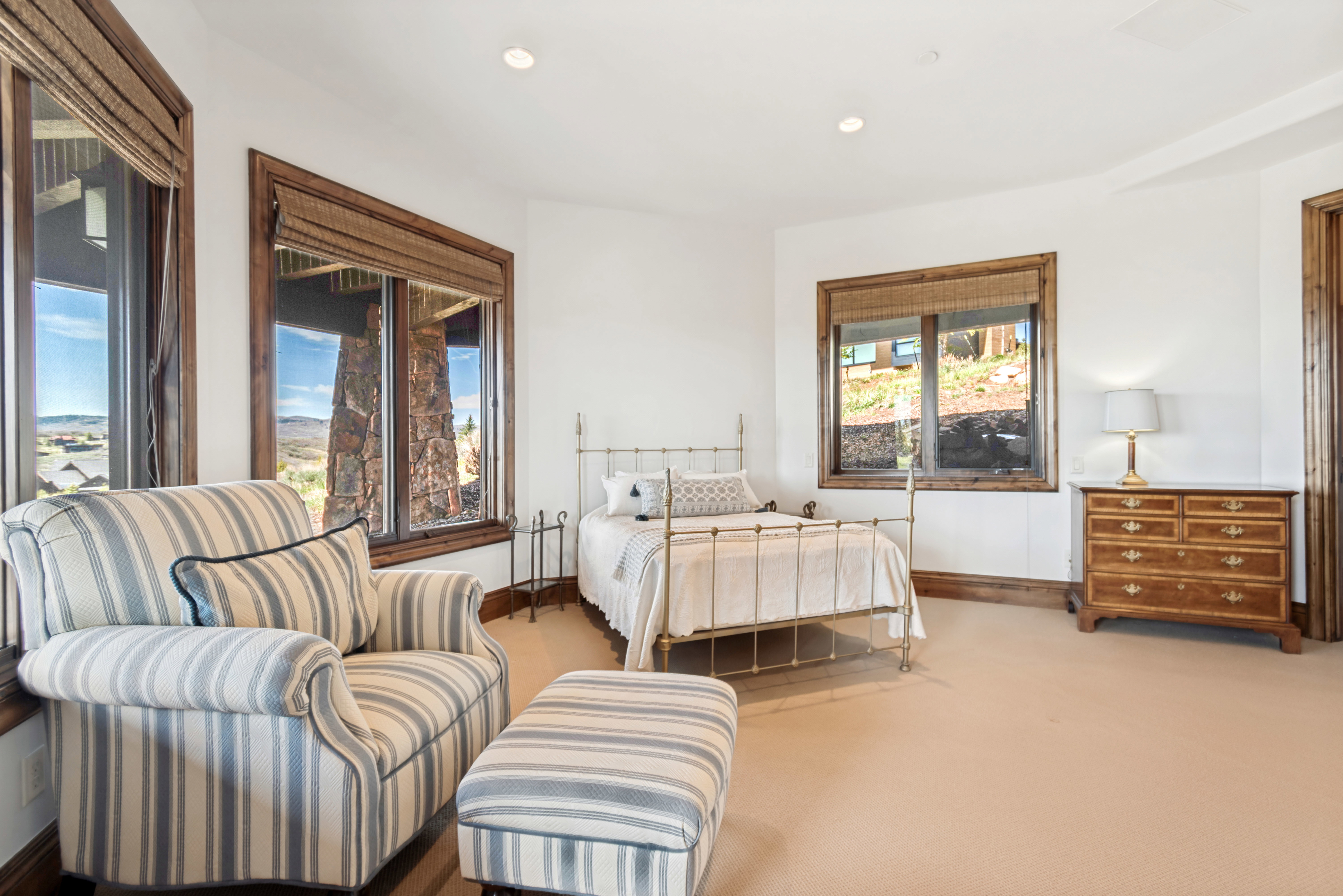 Light-filled interior space featuring multiple windows with wood trim and woven Roman shades