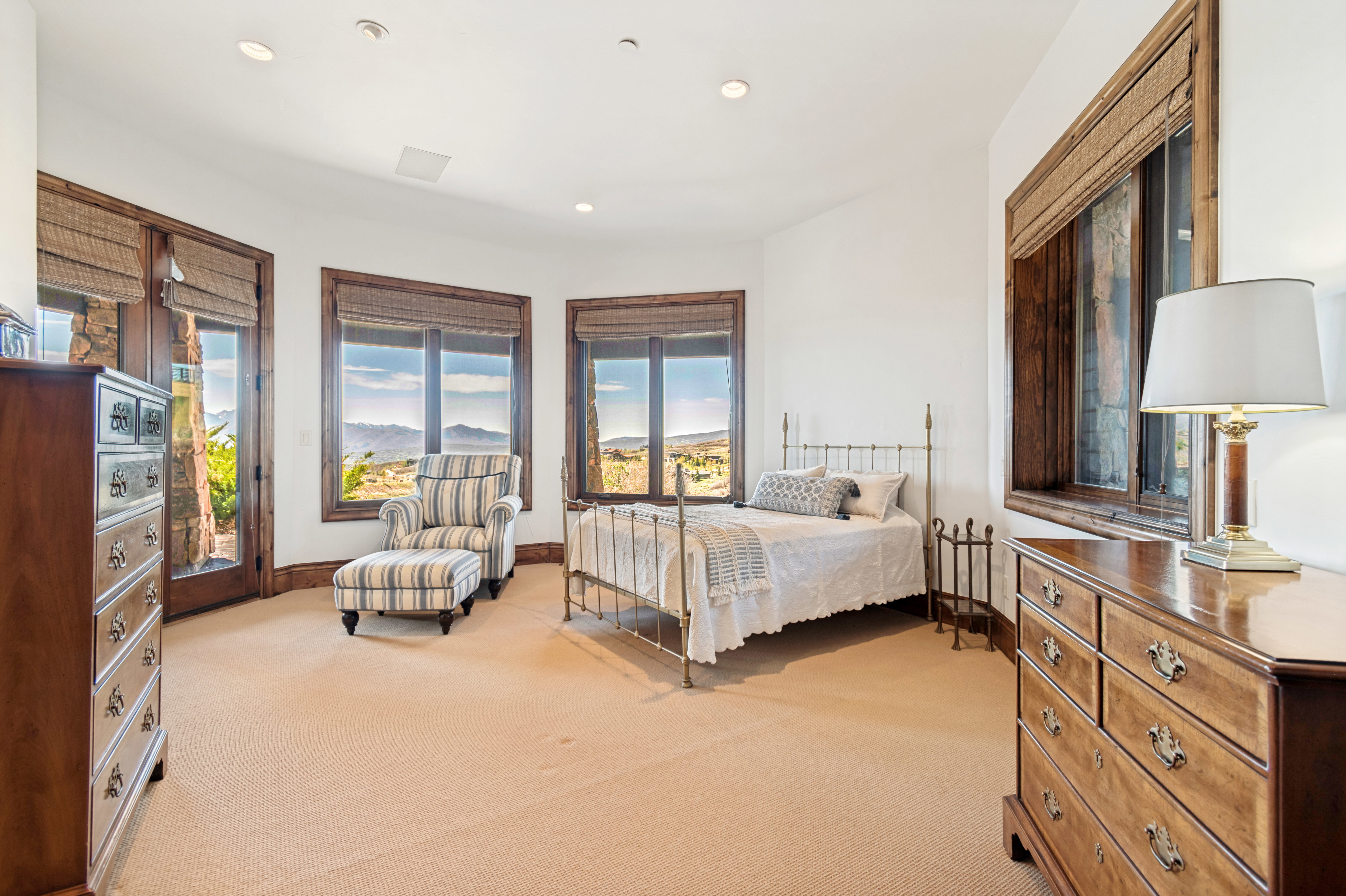 Carpeted room with multiple large windows, dark wood trim, and recessed lighting