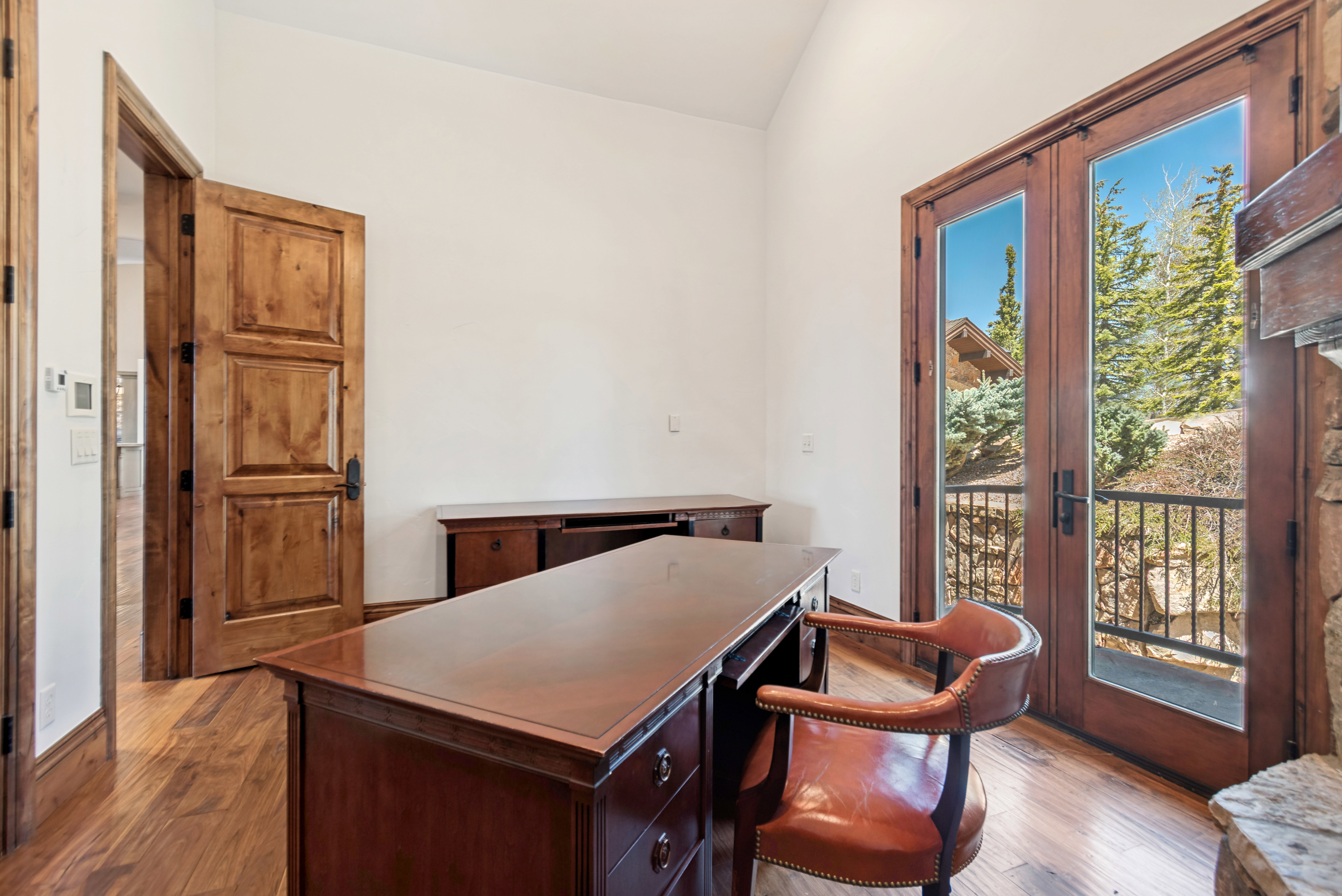 Room featuring wood-finish flooring, white walls, and a vaulted ceiling