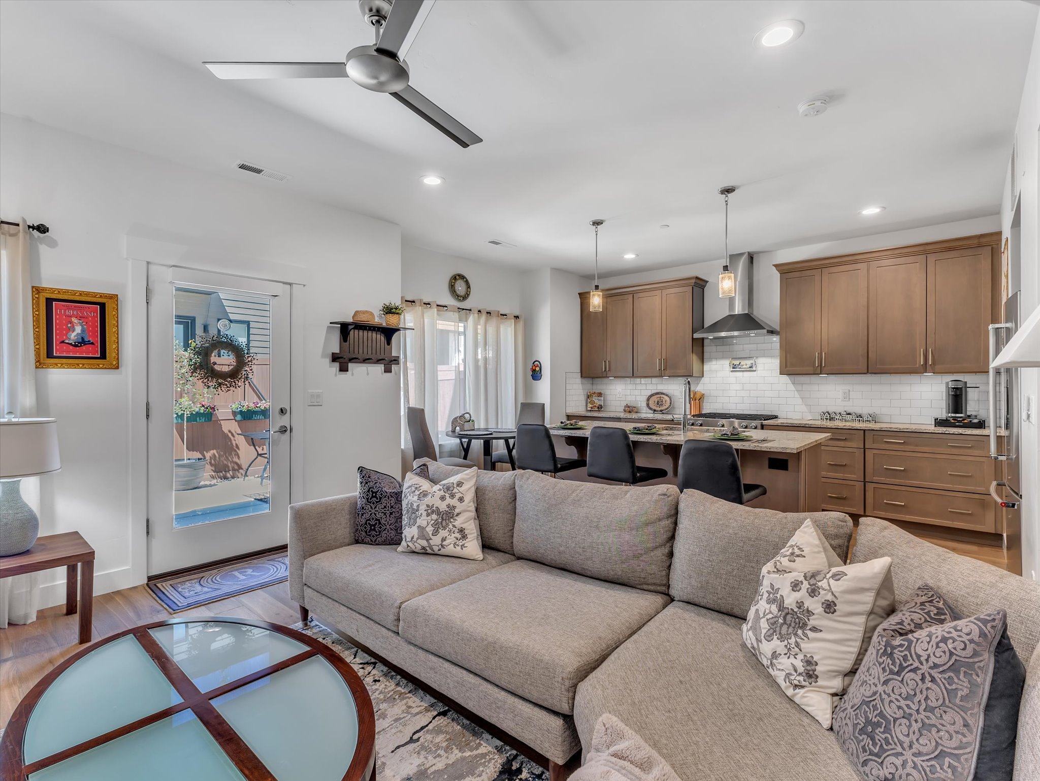 Open-concept living space featuring wood-finish flooring, recessed lighting, and a contemporary ceiling fan