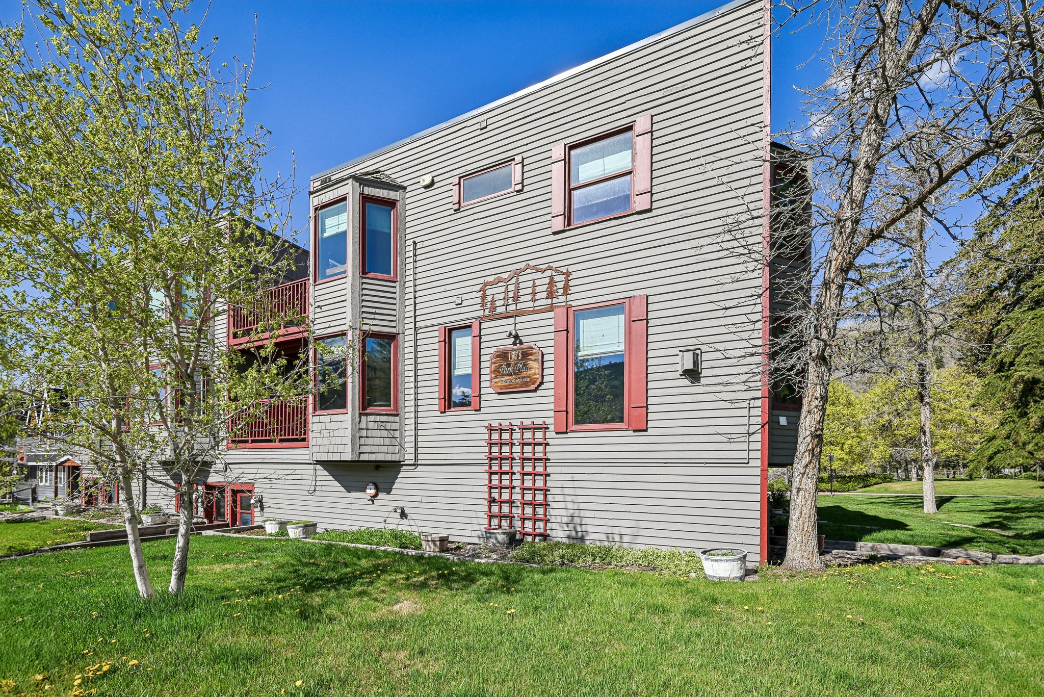Multi-story exterior with horizontal siding and red window shutters