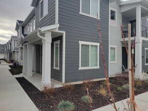 Contemporary townhome exterior featuring dark gray horizontal siding and white trim