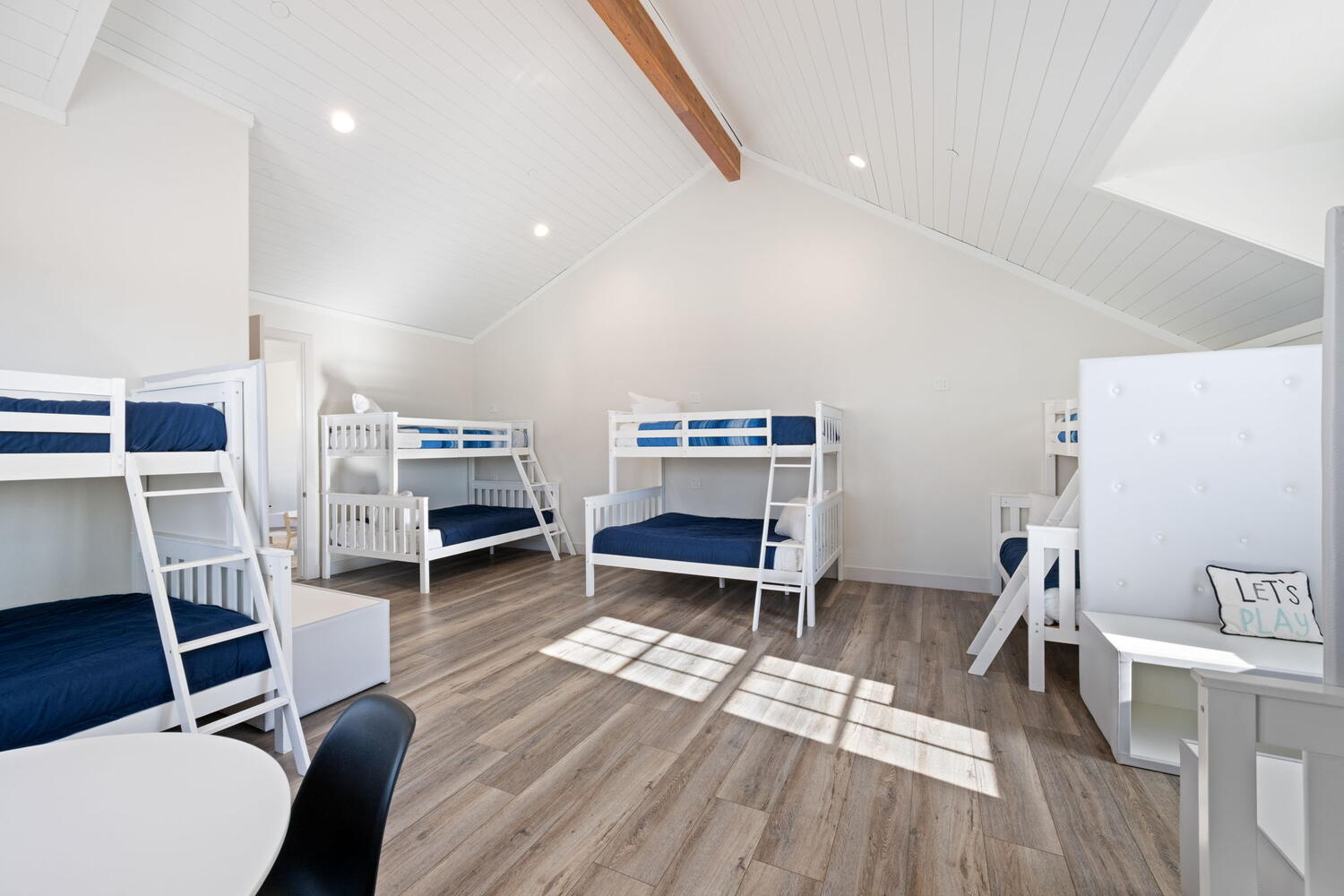 Vaulted shiplap ceiling with exposed wood beam and recessed lighting