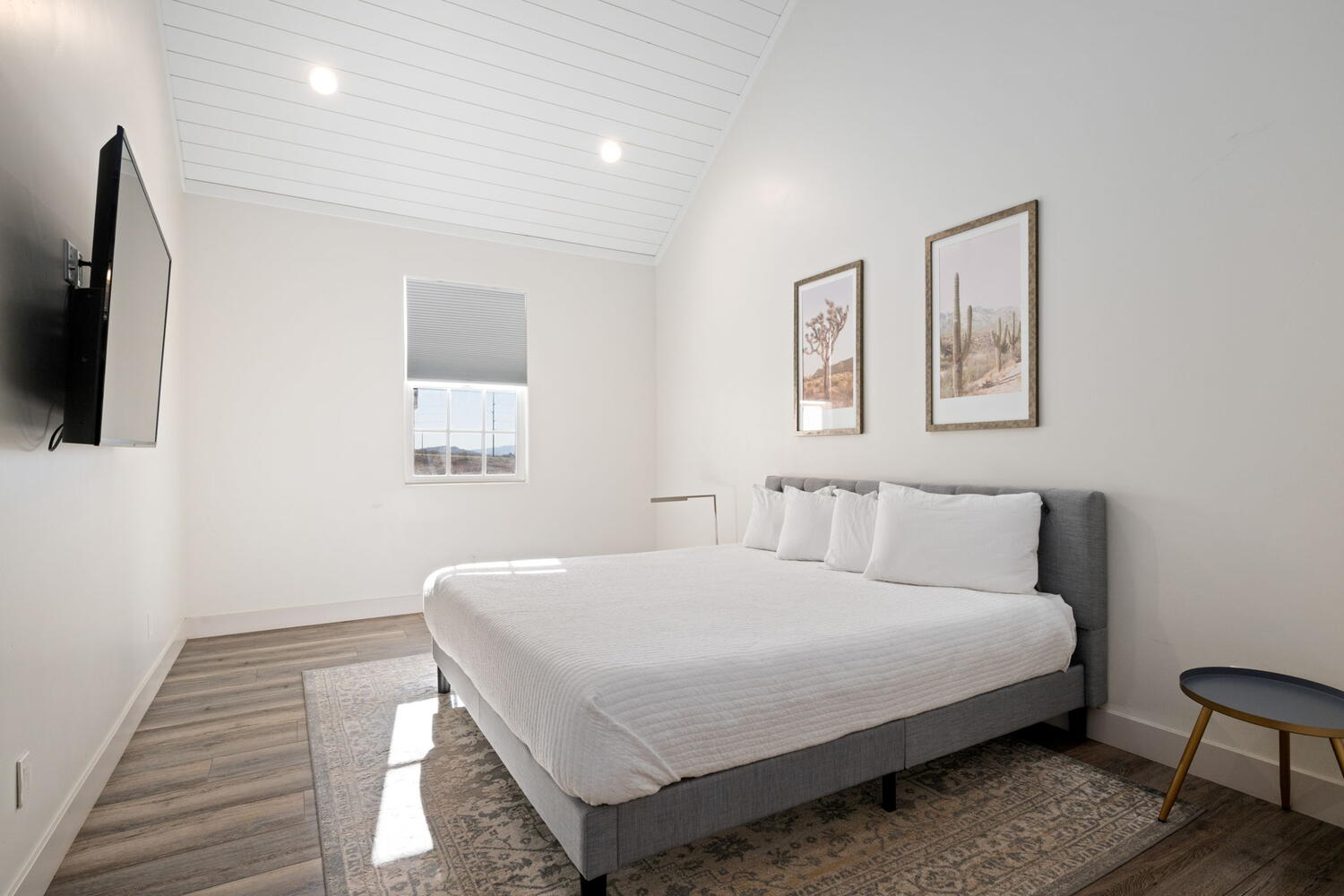 Bedroom featuring wood-finish flooring, a vaulted shiplap ceiling with recessed lighting, and a window with a roller shade