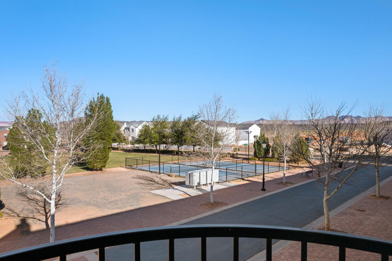 Community amenities featuring a central lawn, mature trees, and sports courts