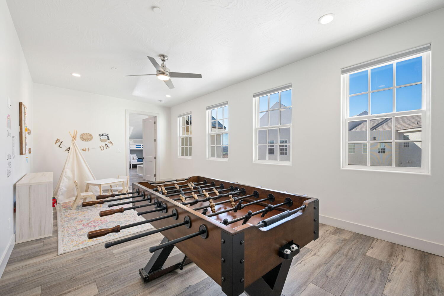 Entertainment room featuring wood-finish flooring, recessed lighting, and a contemporary ceiling fan