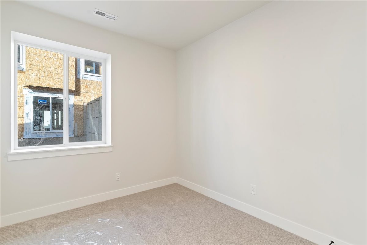 Neutral-toned wall finishes with a single window featuring white trim