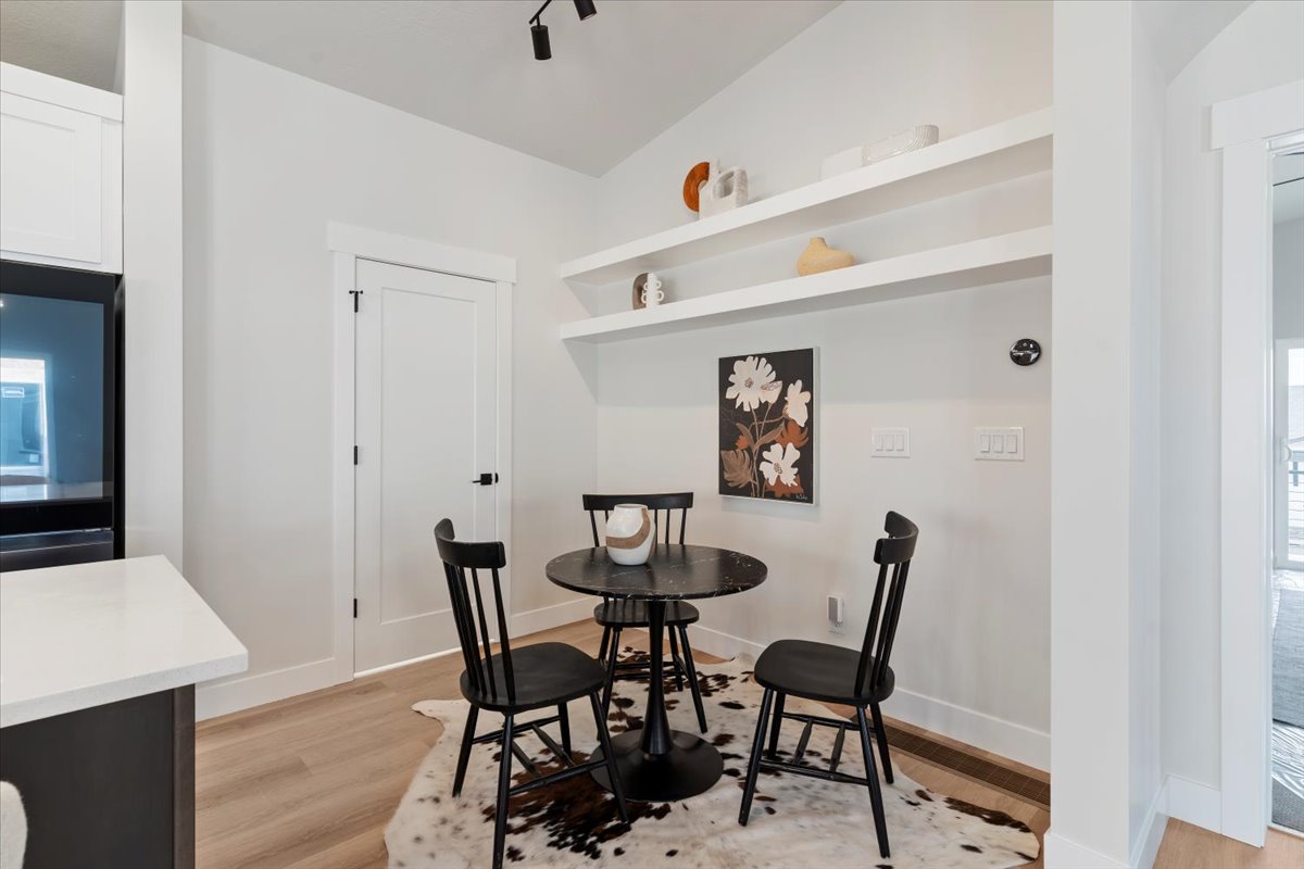 Built-in shelving with recessed wall space, light wood-finish flooring, white baseboards, and white door trim