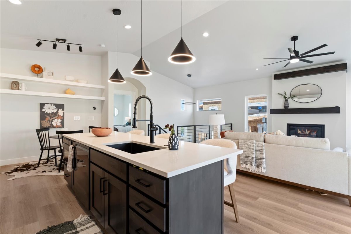 Kitchen island featuring a black sink, a matte black faucet, and pendant lighting