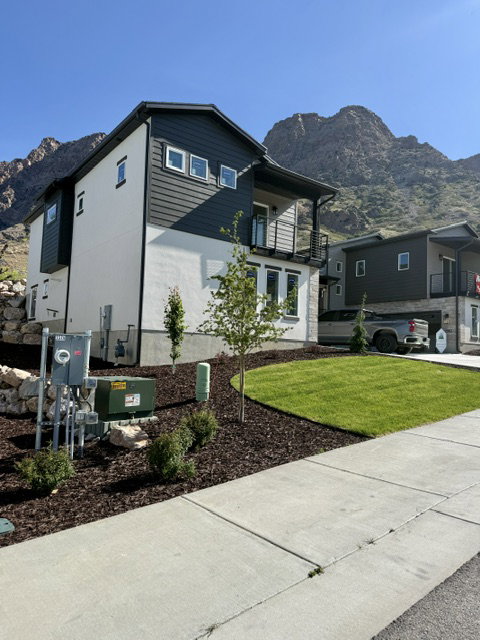 Modern architectural exterior featuring white stucco and dark horizontal siding