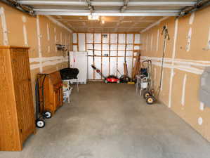 Spacious garage featuring concrete flooring and exposed wall studs