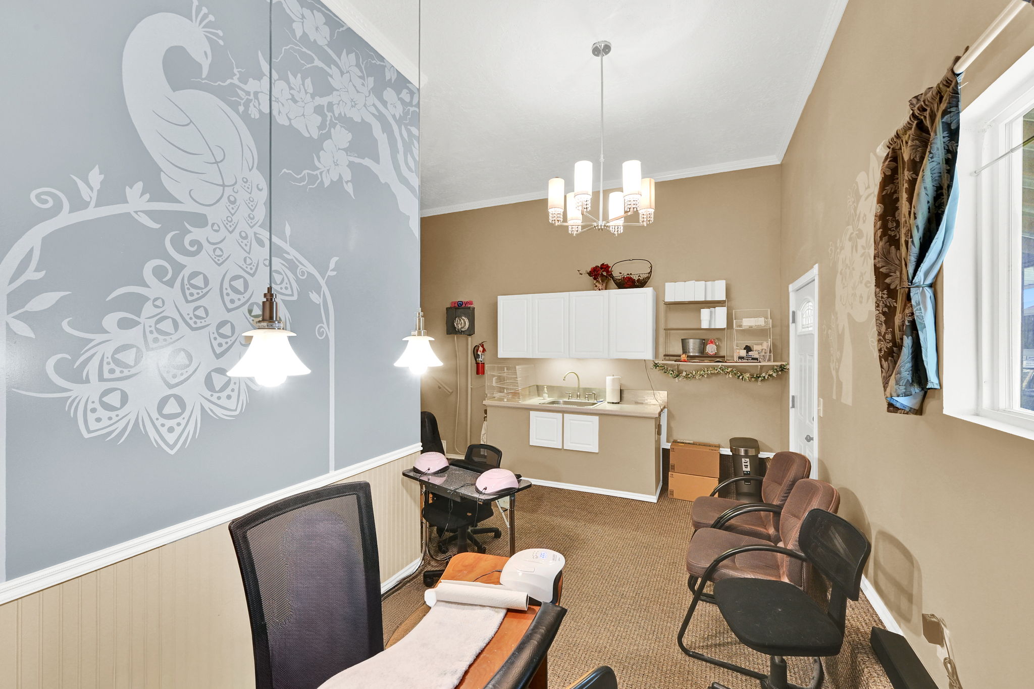Accent wall with decorative peacock motif, contrasting neutral wall tones, beadboard wainscoting, recessed lighting, and a modern chandelier