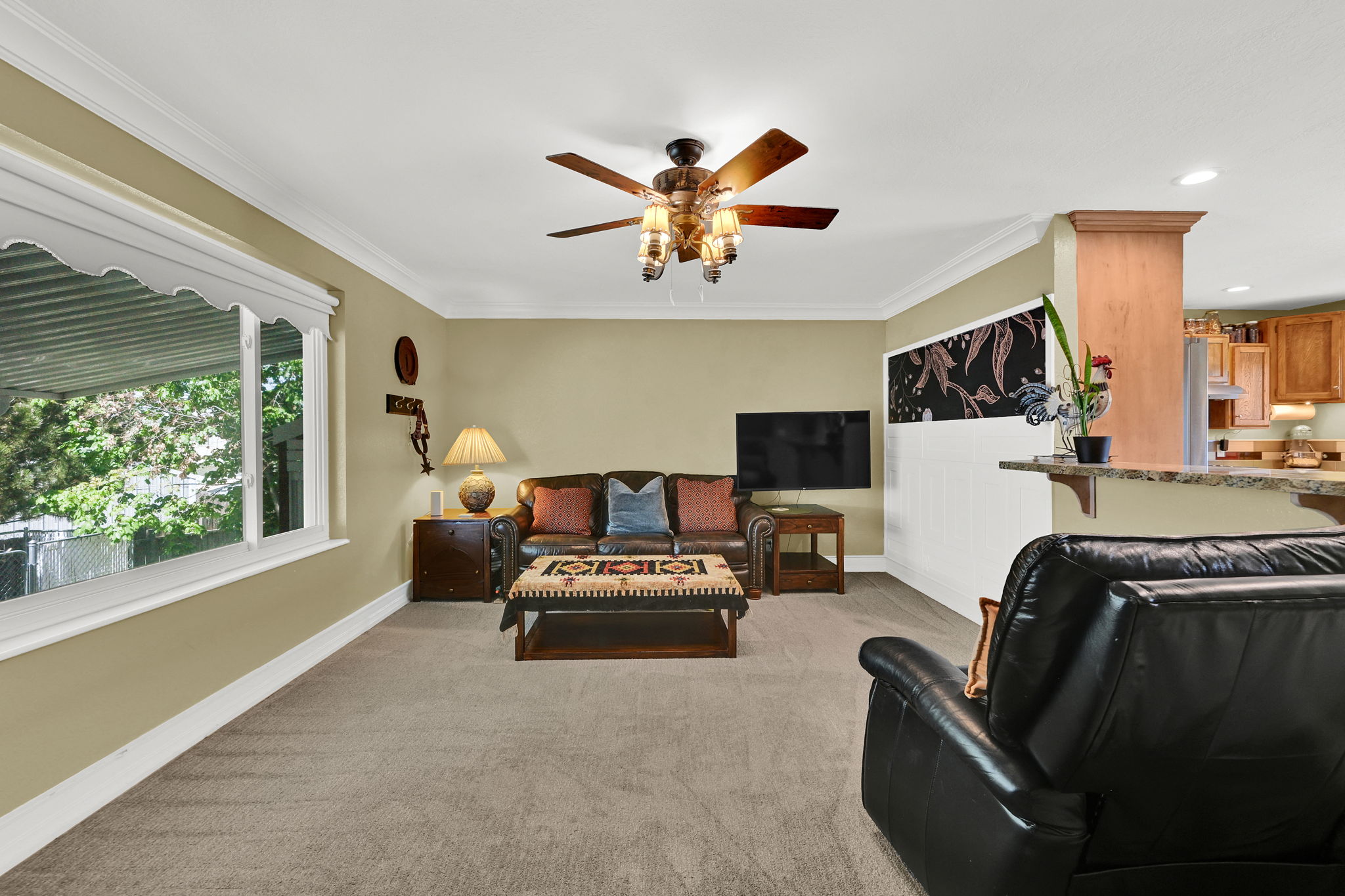Living area featuring light beige wall paint and crown molding