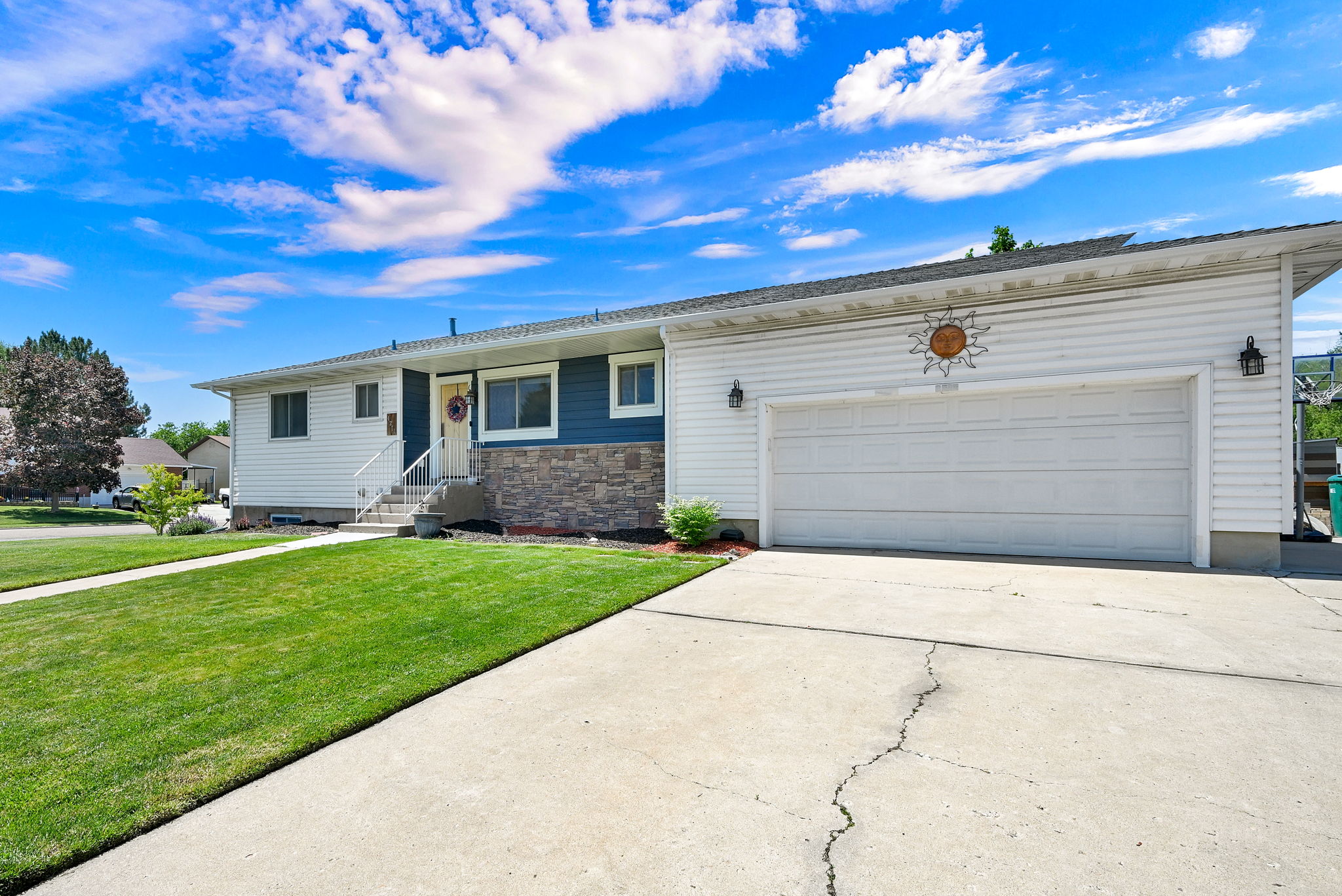 White vinyl siding exterior with blue accent siding and stone veneer detailing