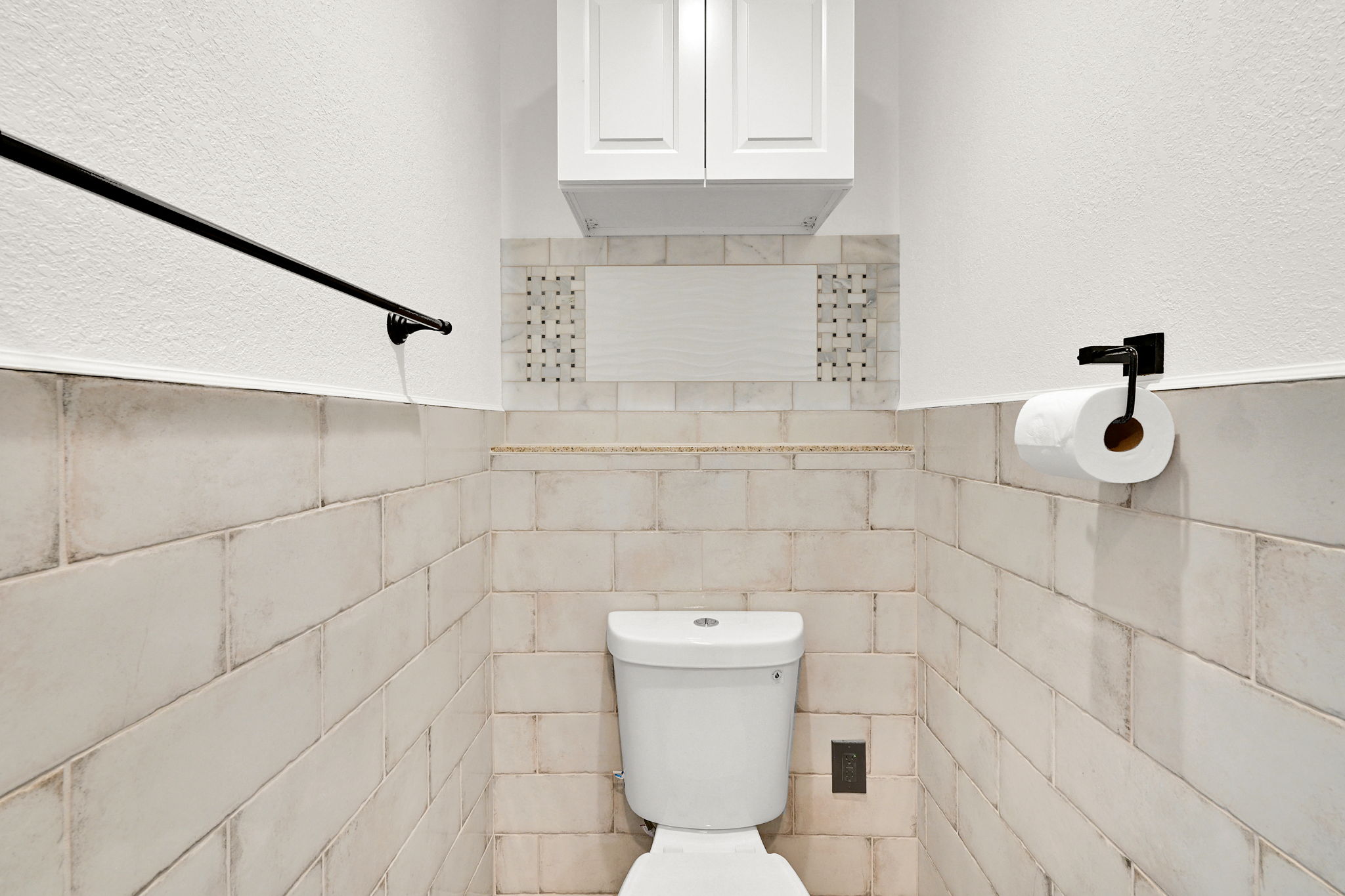 White subway tile wainscoting with accent tile detailing
