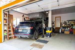 Spacious garage featuring a concrete floor, overhead door, and an interior access door with wood trim