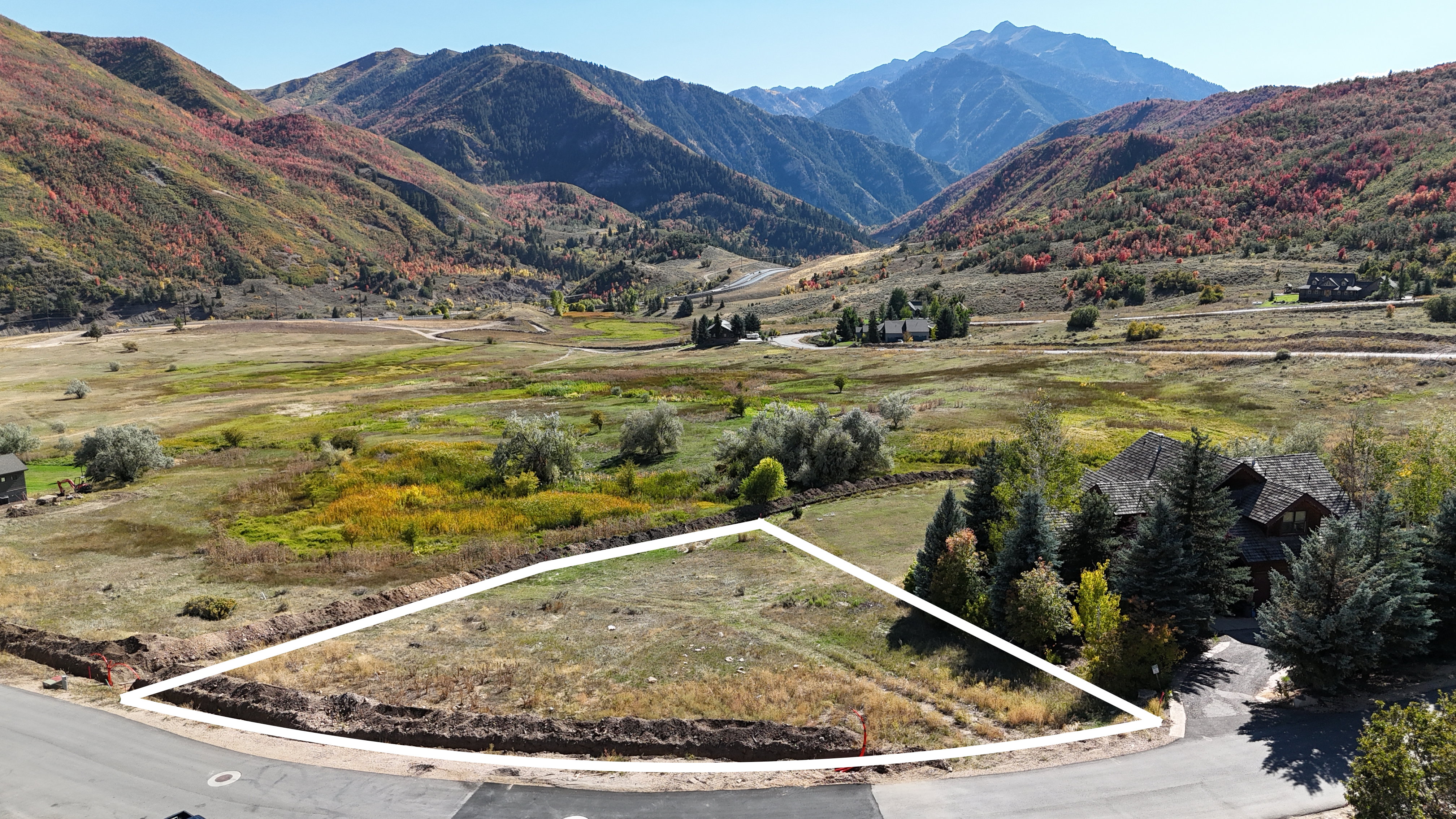 Expansive land parcel with surrounding mountain scenery and mature trees