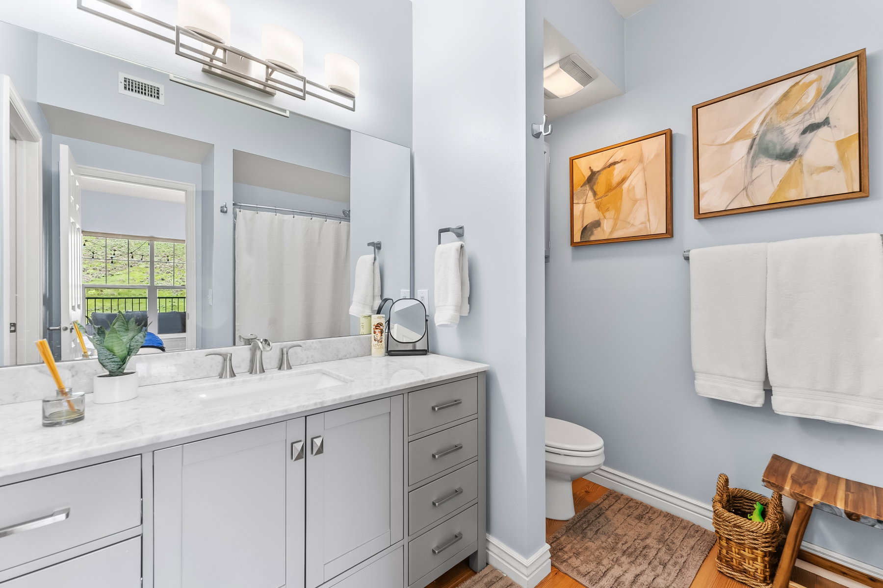 Bathroom featuring a double vanity with a light gray cabinet base, white countertop, and dual sinks