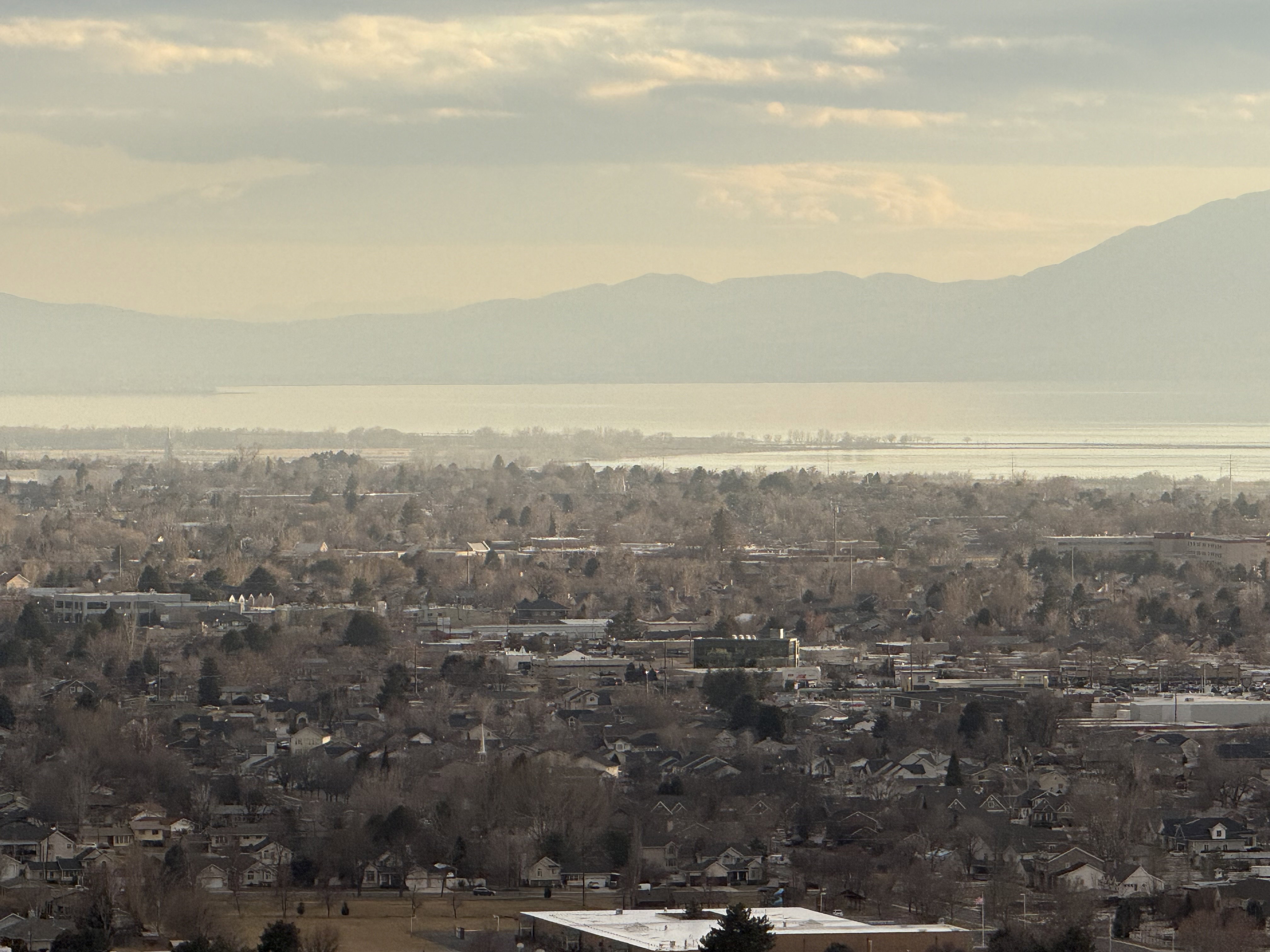 Elevated perspective showcasing a broad urban landscape with distant mountains and a body of water