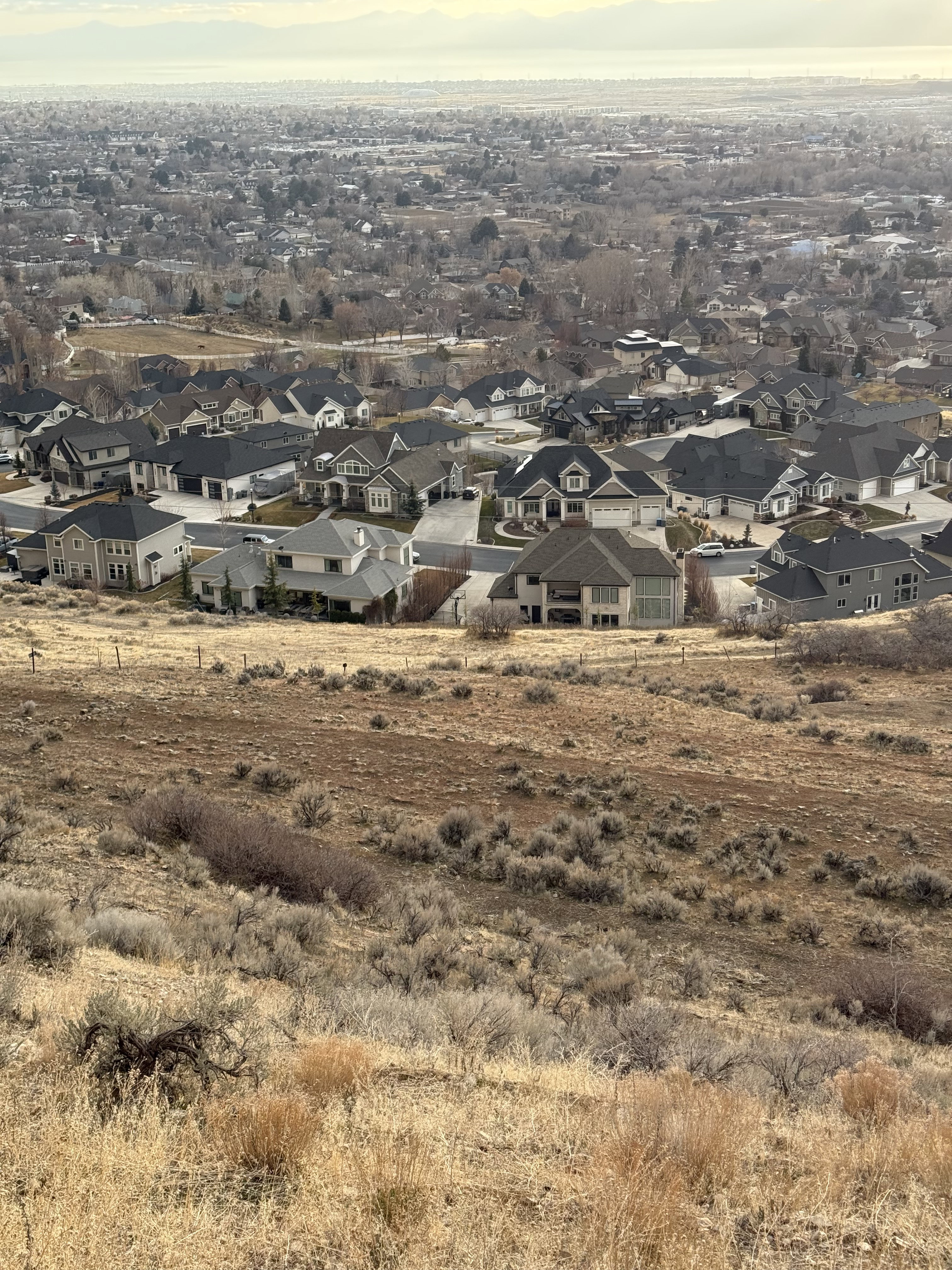 Expansive undeveloped land featuring natural grasses and brush, offering a sloping terrain