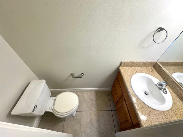 Bathroom vanity featuring a laminate countertop, integrated sink, and wood-finish cabinetry
