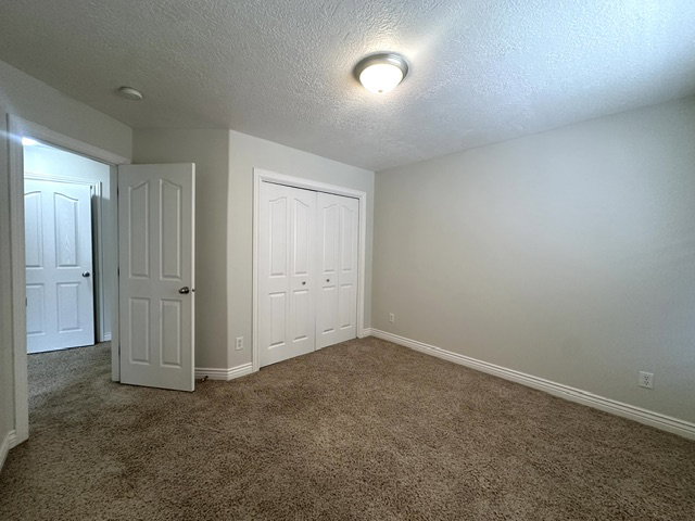 Bedroom featuring a double bifold closet, neutral wall paint, and light brown carpeting